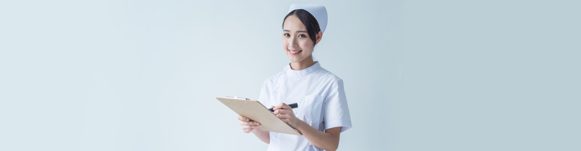 nurse smiling while carrying clipboard